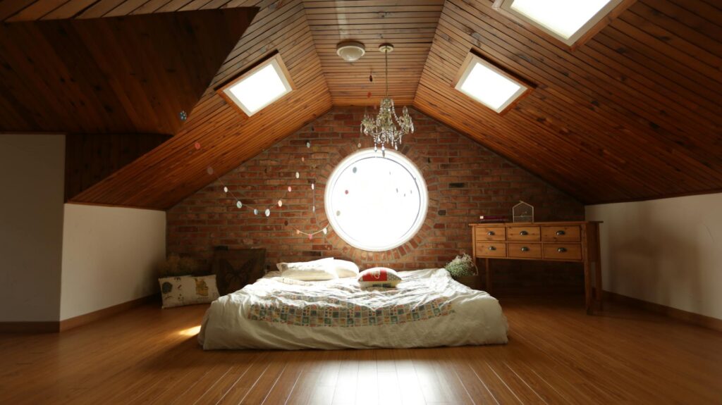 A warm and inviting attic bedroom featuring a unique brick wall and wooden ceiling design.